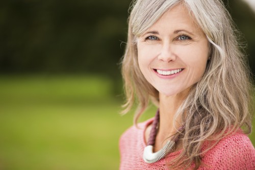 Close Up Of Radiant Mature Woman Standing In Park