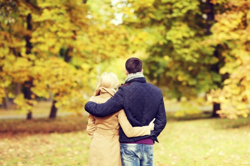couple hugging in autumn park from back